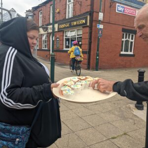 resident handing out cupcakes to the local public