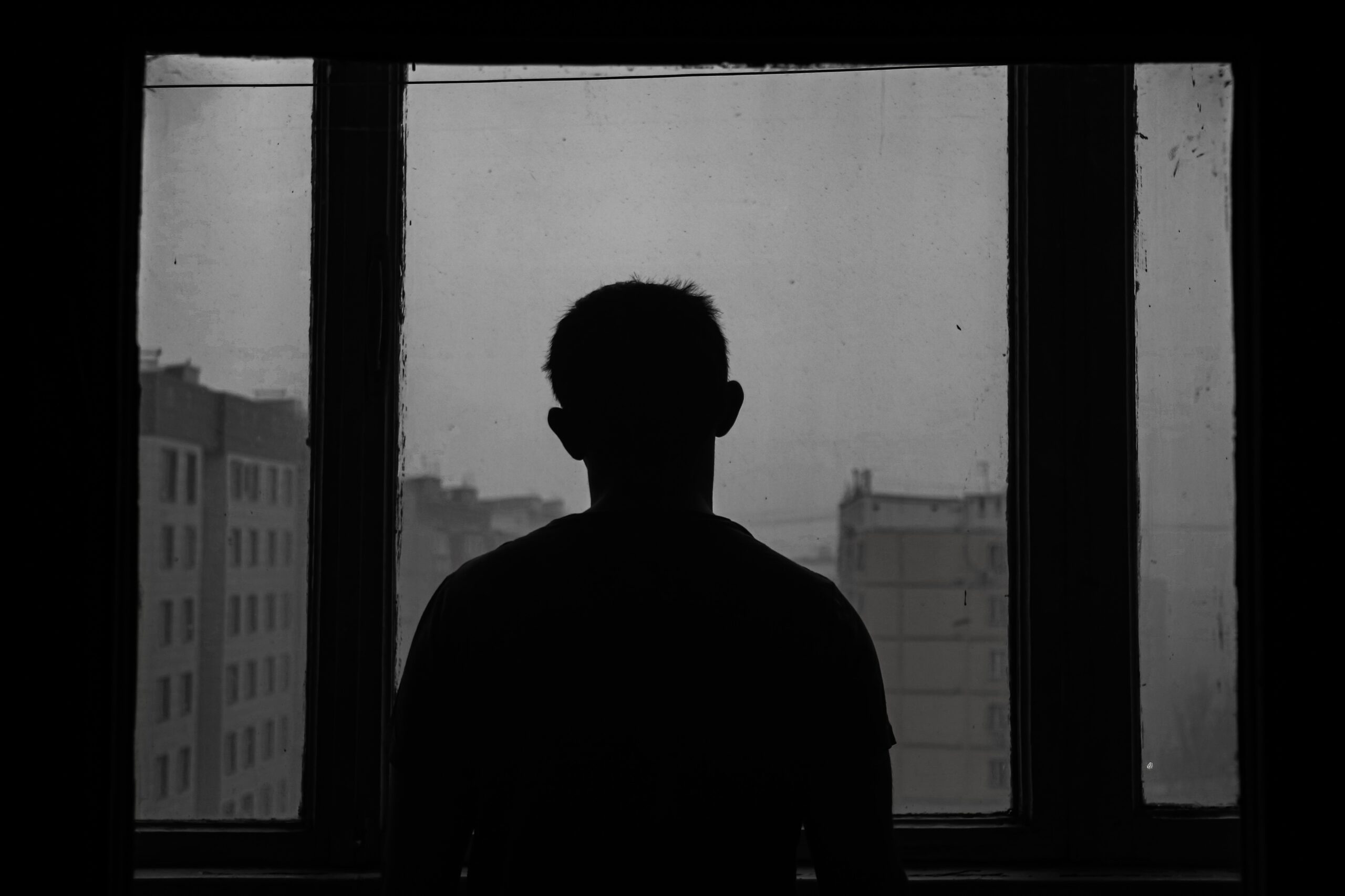 black and white image of a man silhouetted in a window