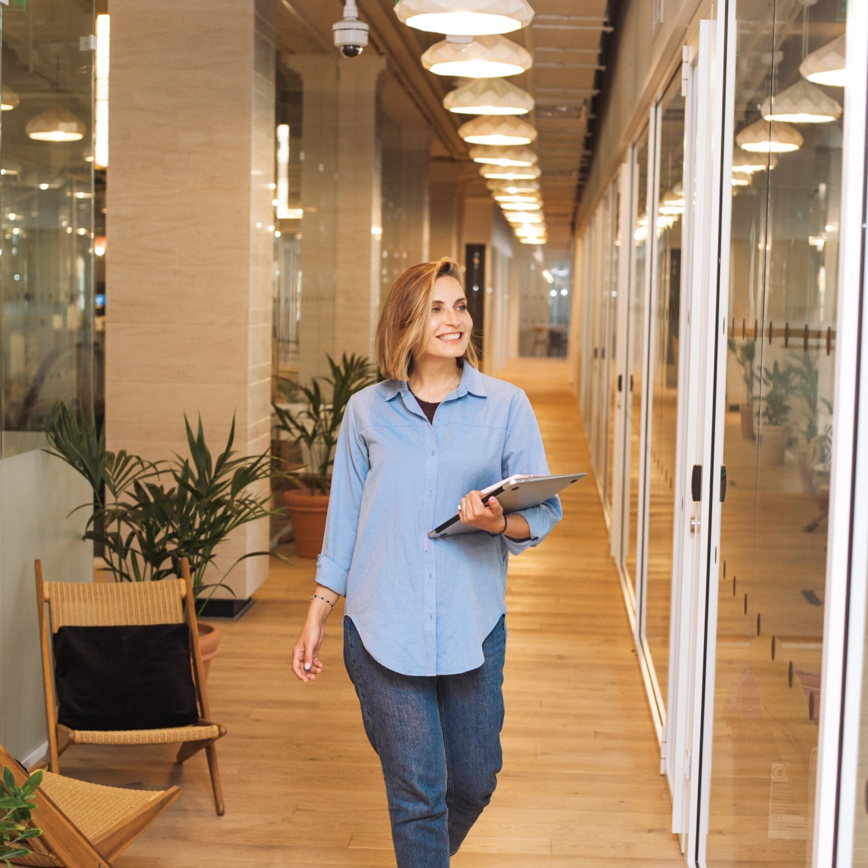 woman holding clipboard walking down corridor