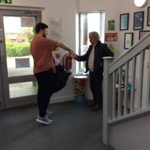one male handing another male easter egg