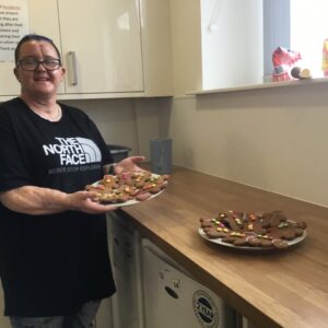 resident holding plate of homemade vegan gingerbread biscuits