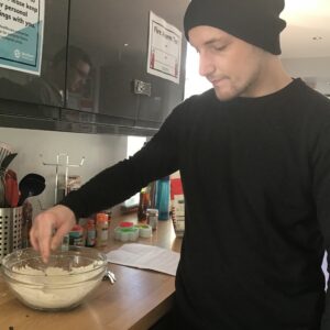 resident adding ingredients to mixing bowl