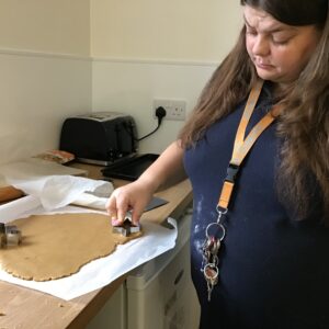 resident using cookie cutter to cut out gingerbread cookies