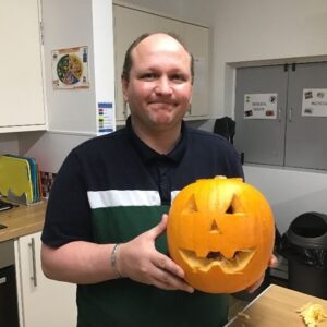 resident holding carved pumpkin