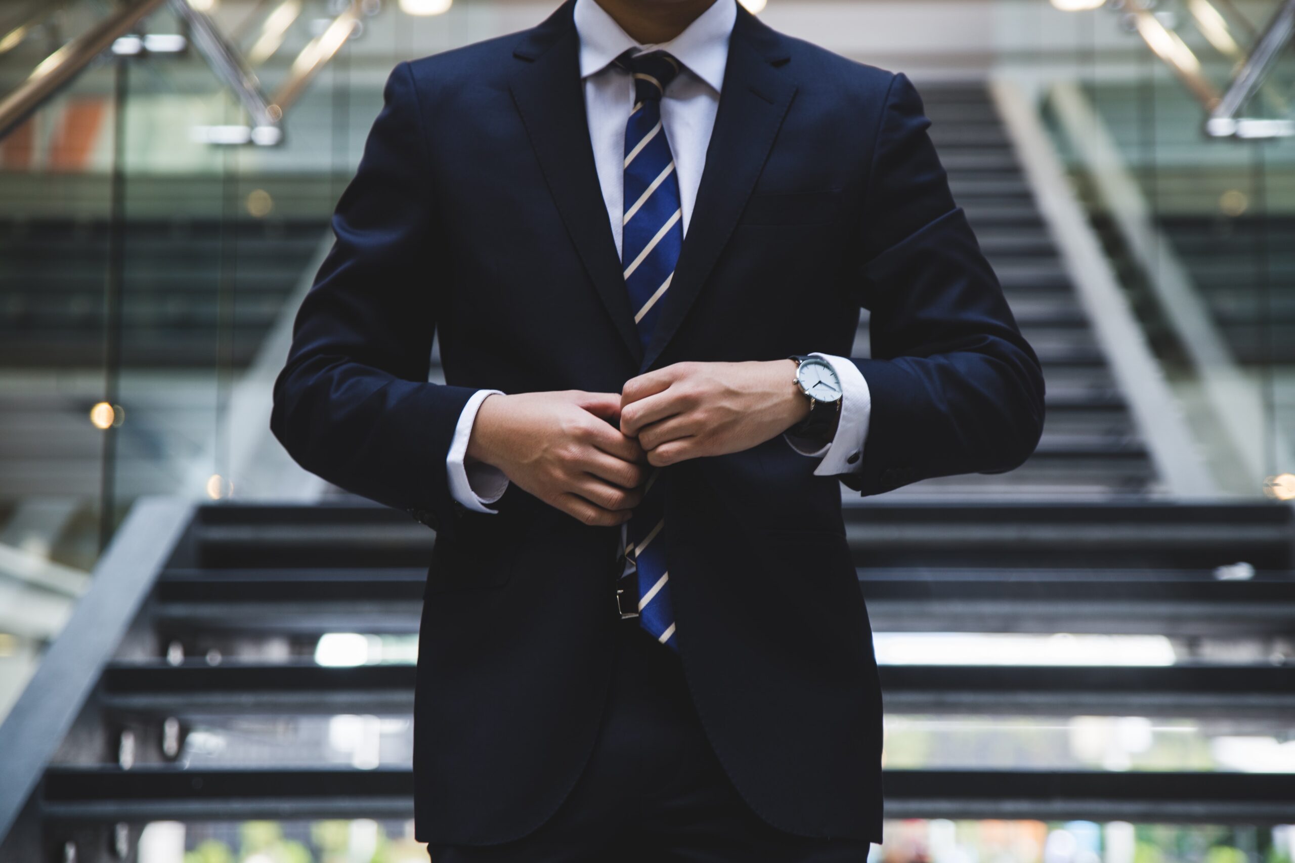 man in suit buttoning up his jacket