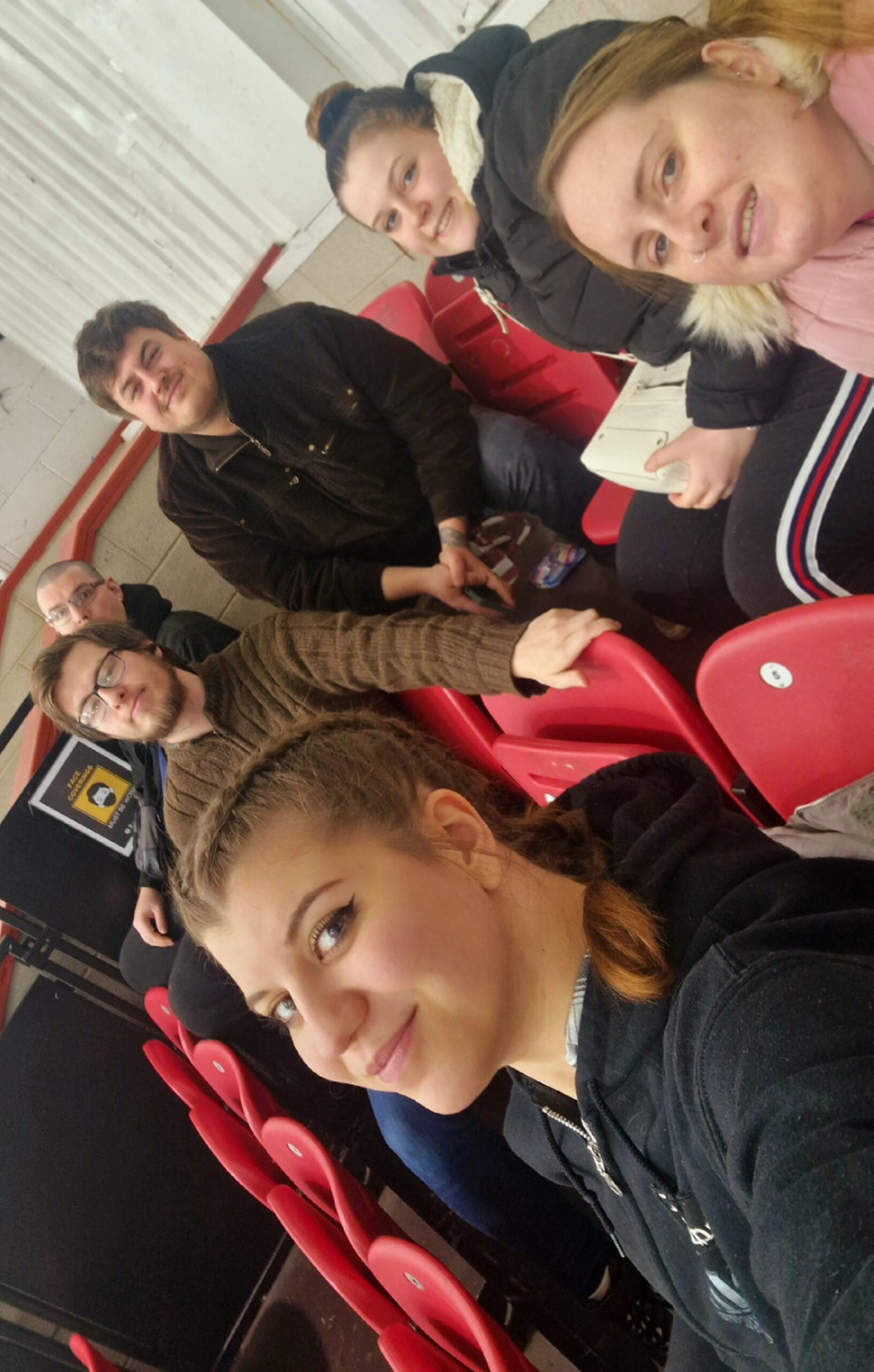 residents and team members in the crowd watching a game of ice hockey
