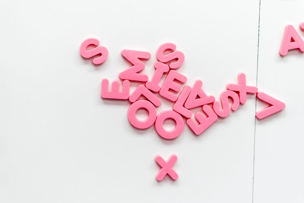 dyslexia focus: jumble of pink coloured letters on white background