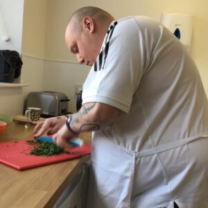 male resident chopping vegetables