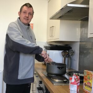 resident stirring curry in pan