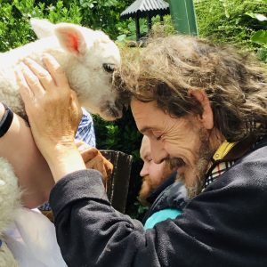 resident touching foreheads with a lamb