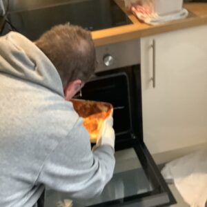 resident putting homemade lasagne in the oven