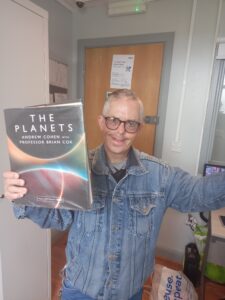 male holding book about planets