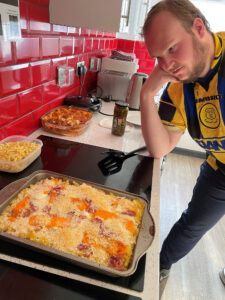 resident next to tray of homemade freshly cooked mac & cheese