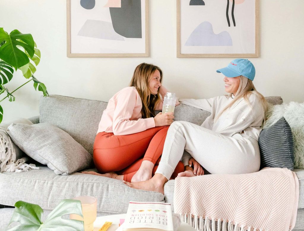 Two girls relaxing at home highlighting the psychological benefits our environment can have on our mental health.
