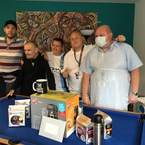 residents and team member posing with coffee machine