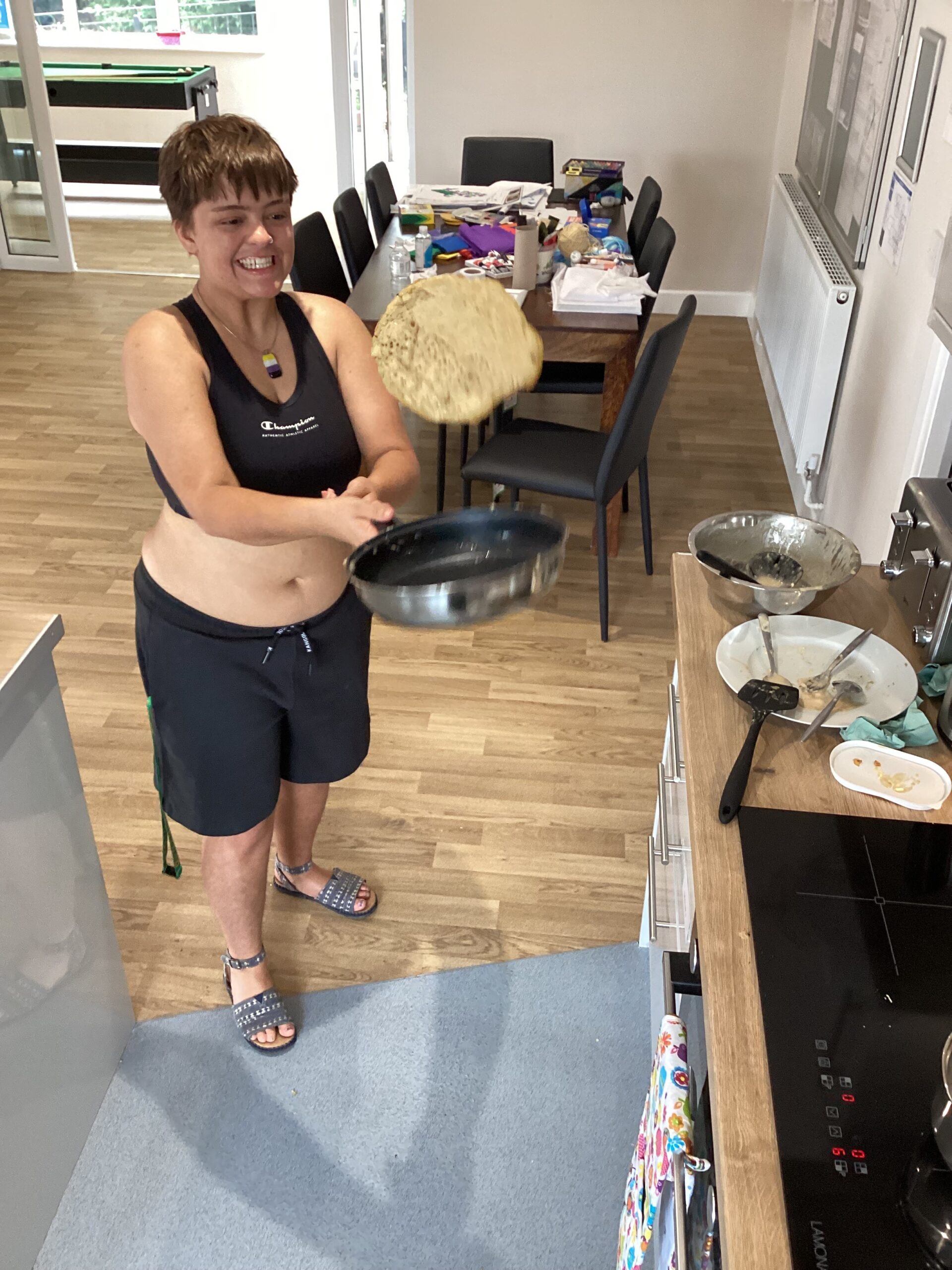 female resident flipping pancake