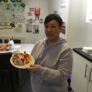 Staff member holding plate of pancakes