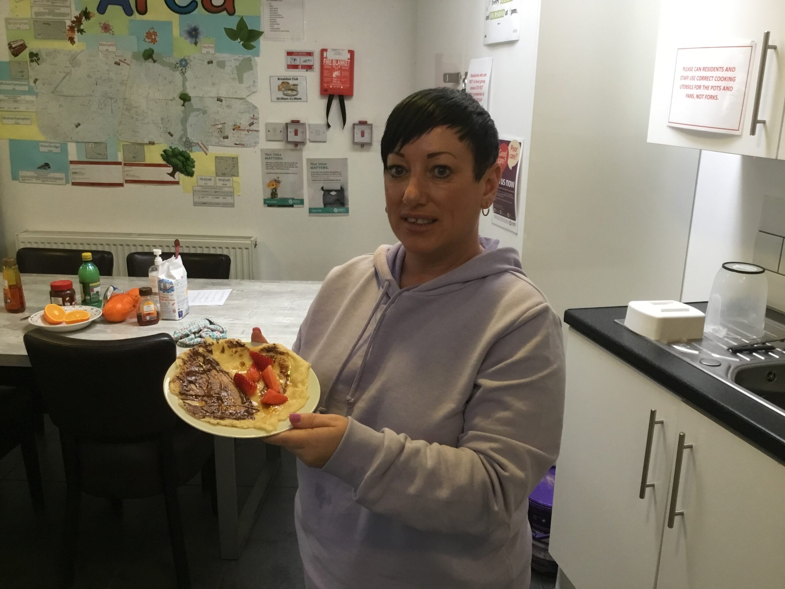 Staff member holding plate of pancakes