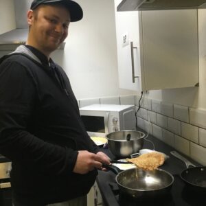 Male resident making pancakes