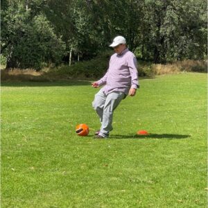 resident kicking red football