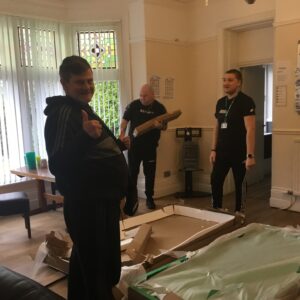 Resident and team member unpacking pool table