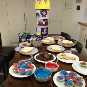 table full of cakes, sandwiches, and biscuits