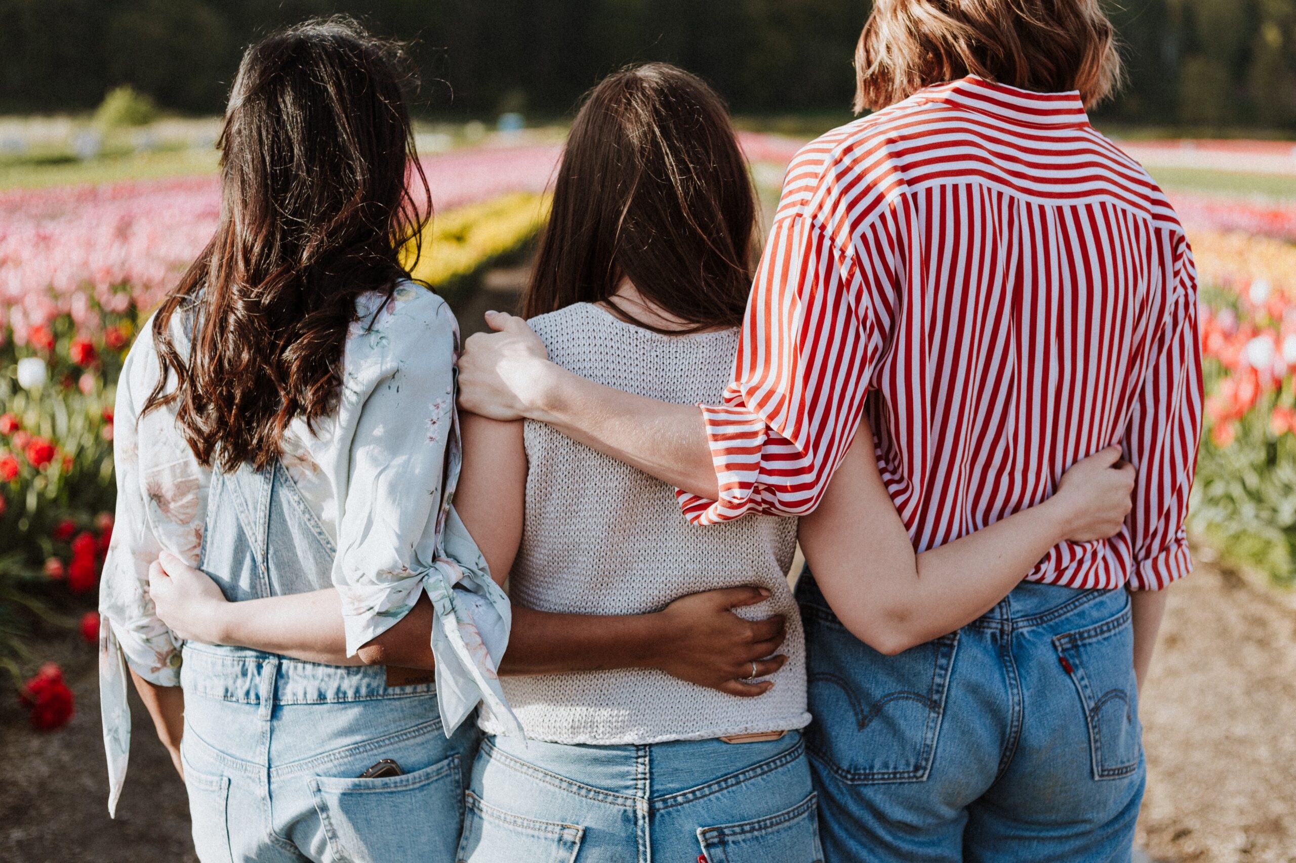 ADHD Awareness Month: 3 women hugging with their backs to camera