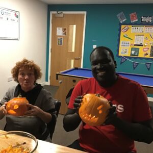 two residents proudly holding their carved pumpkins