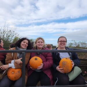 Thress residents holding pumpkins