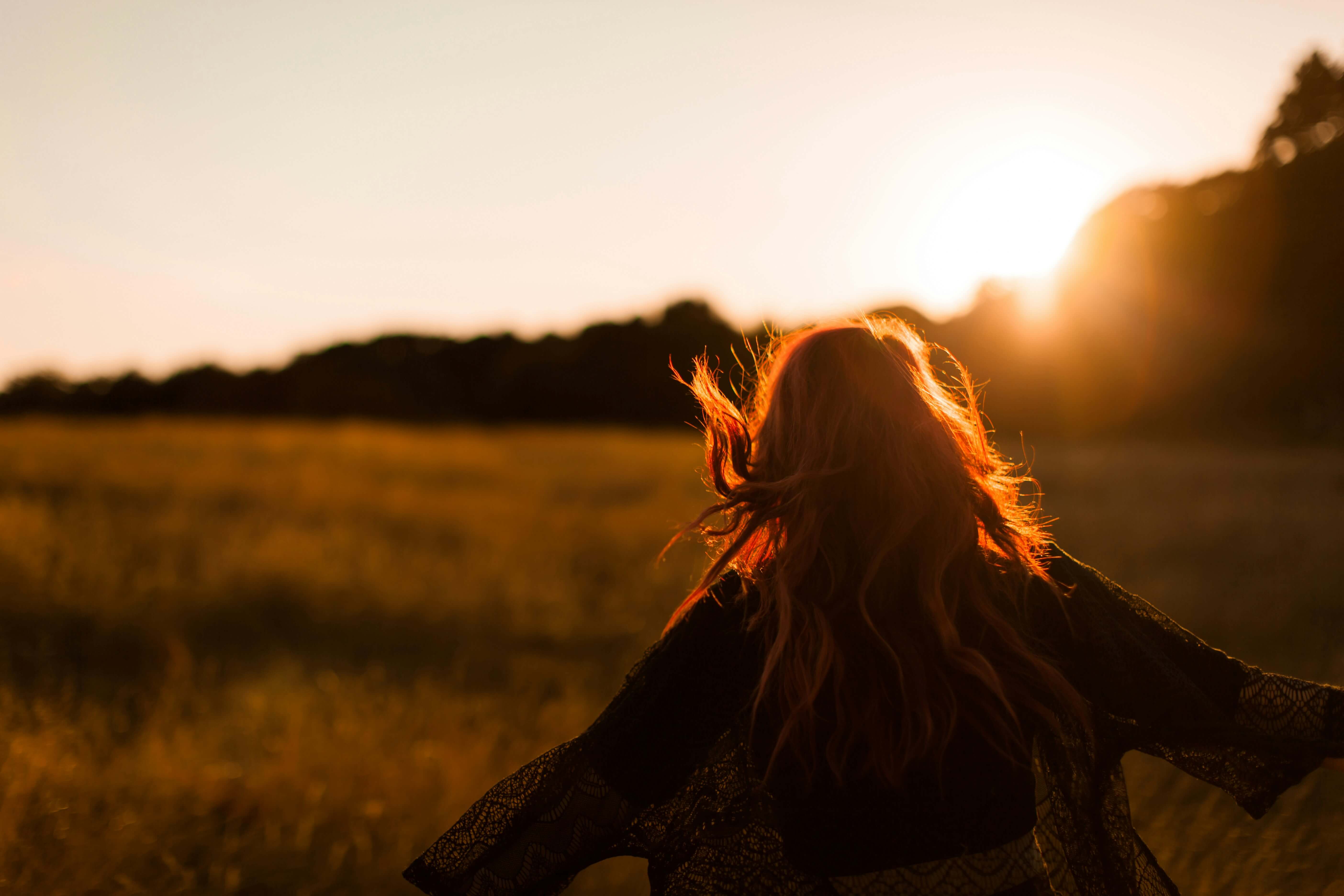 Woman running happily through a field, exemplifying celebrating small wins in recovery.