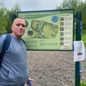 male with sign of park map