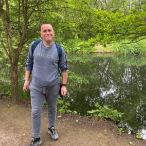 male in front of pond