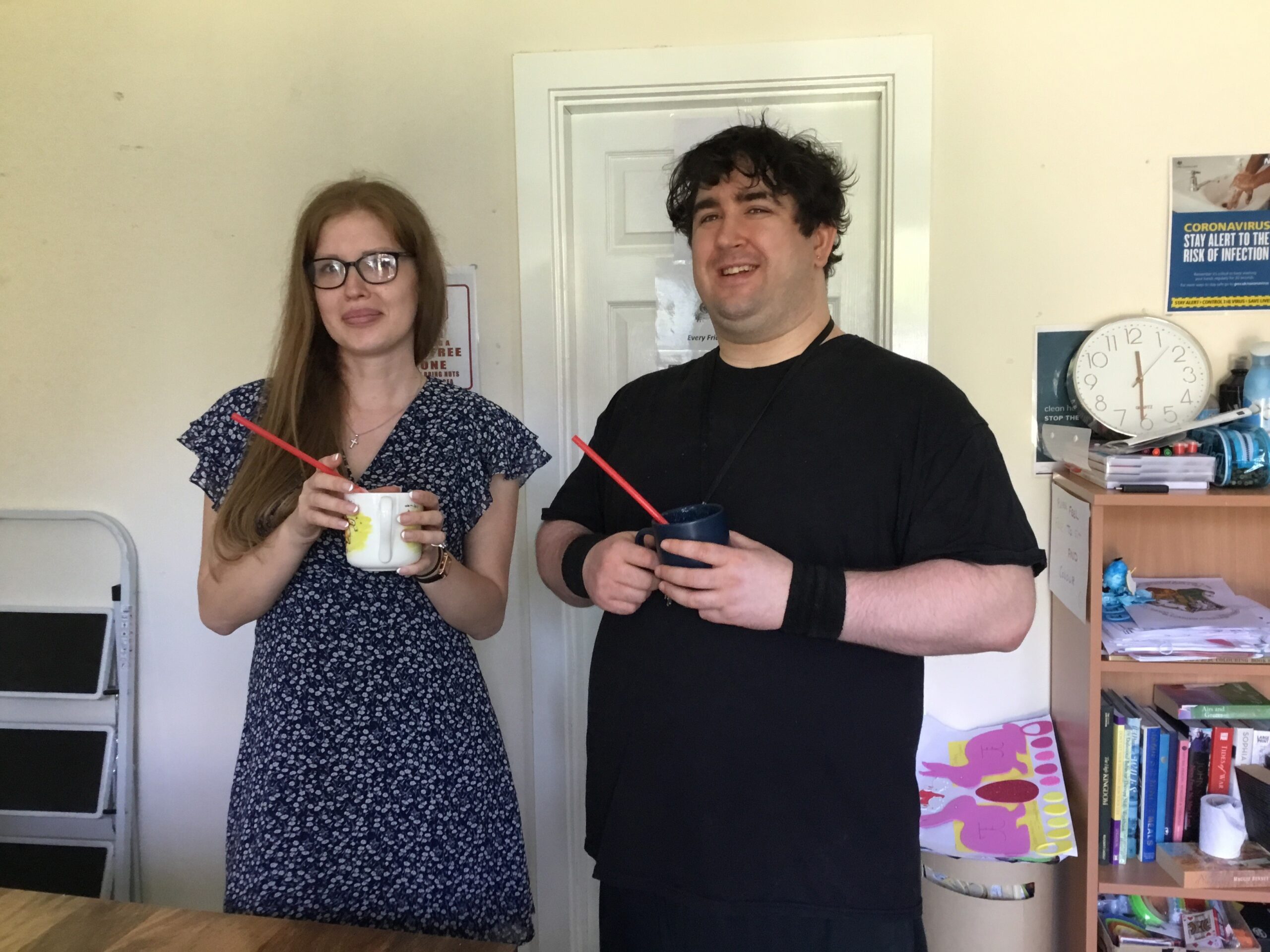 male and female holding drinks cup