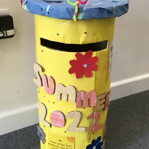 postbox decorated yellow with flowers and "Summer 2022" lettering