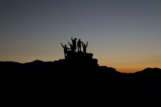 Group of people at the top of a hill celebrating