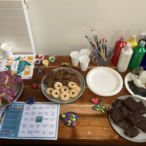 cakes, biscuits and paint pots and paintbrushes on table
