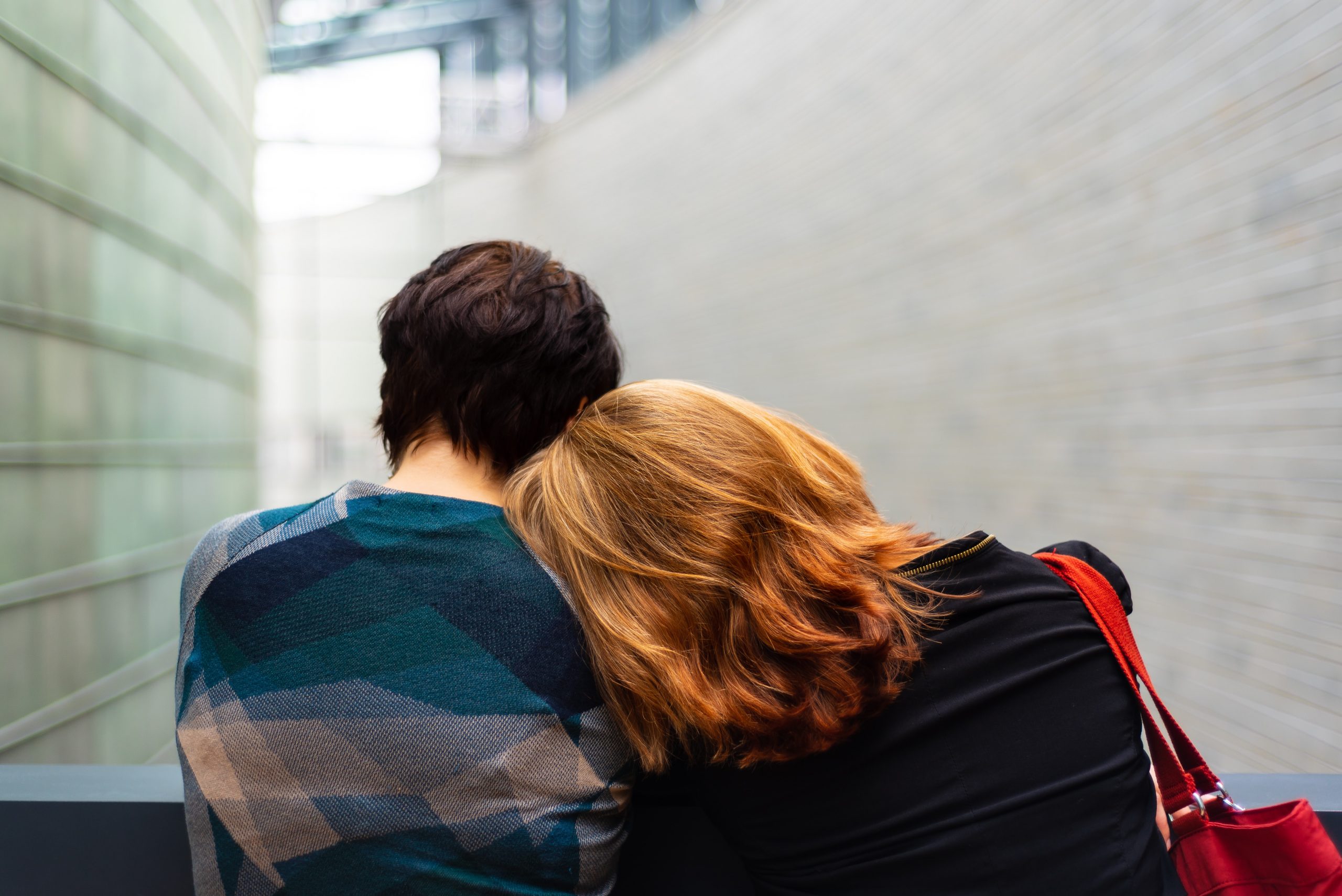 woman resting head on mans shoulder