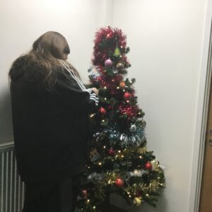 resident putting baubles on Christmas tree