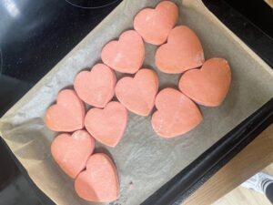 Uncooked red heart-shaped cookies