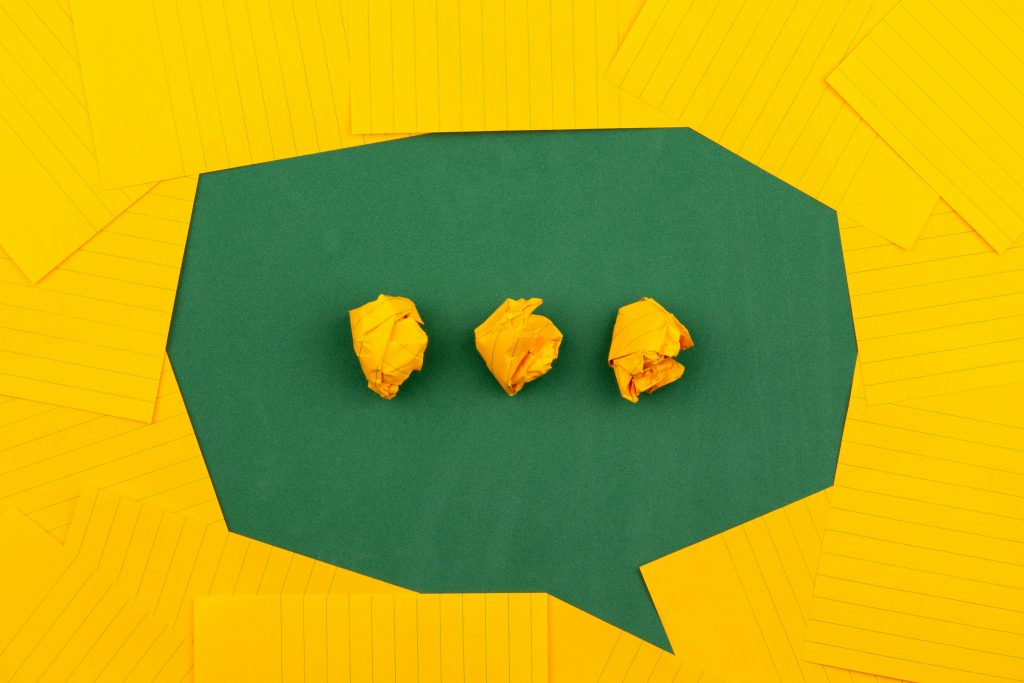 Speech bubble made of green and yellow paper for a blog on talking about mental health in supported living.