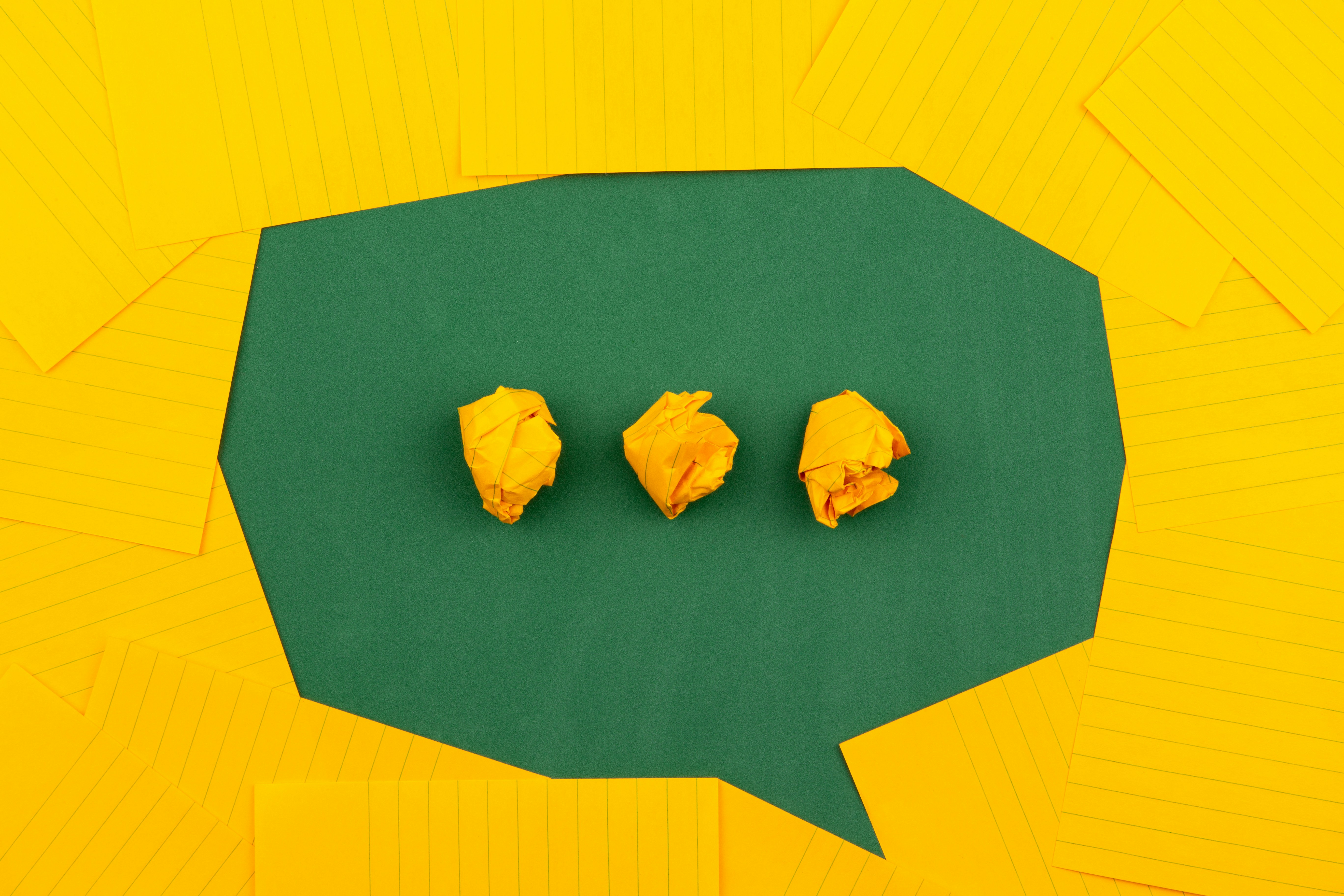 Speech bubble made of green and yellow paper for a blog on talking about mental health in supported living.