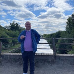 male resident in purple jacket outdoors