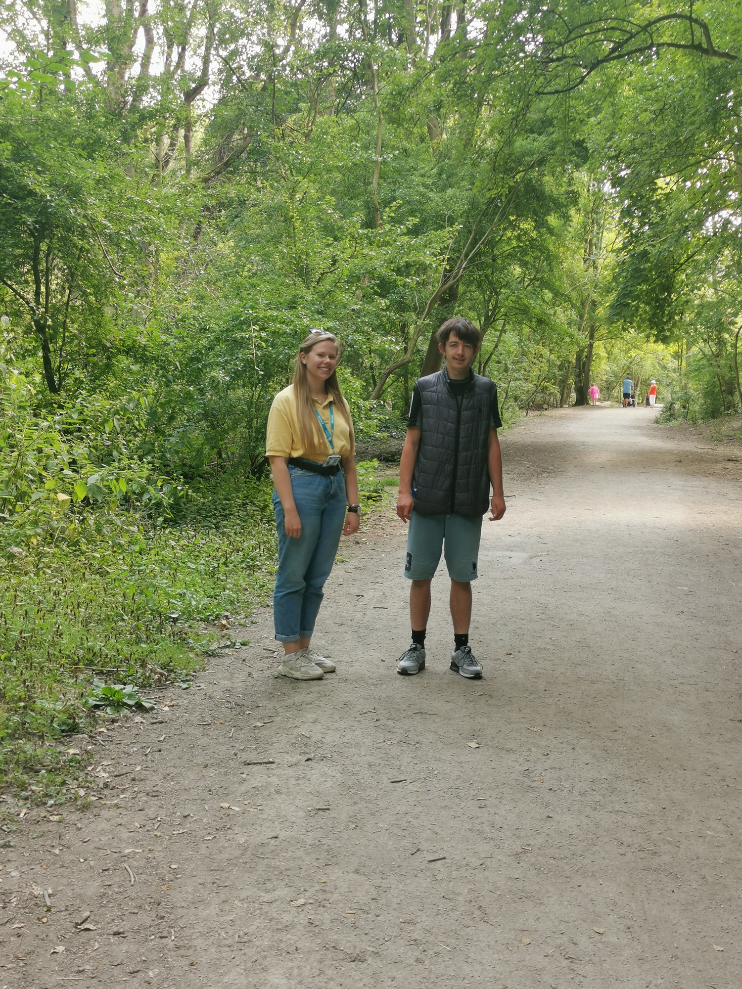 male and female on gravel path among green trees