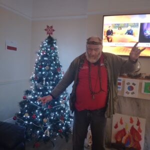 resident standing in front of Christmas tree