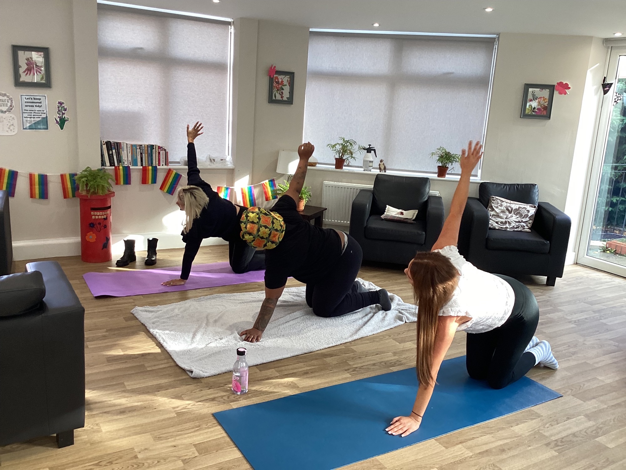 residents and team members in yoga pose kneeling with one arm raised