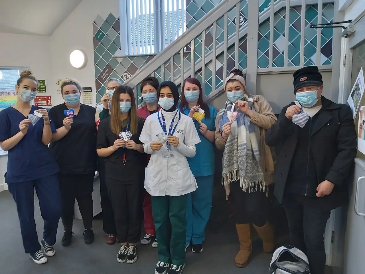 team members posing with sewn hearts