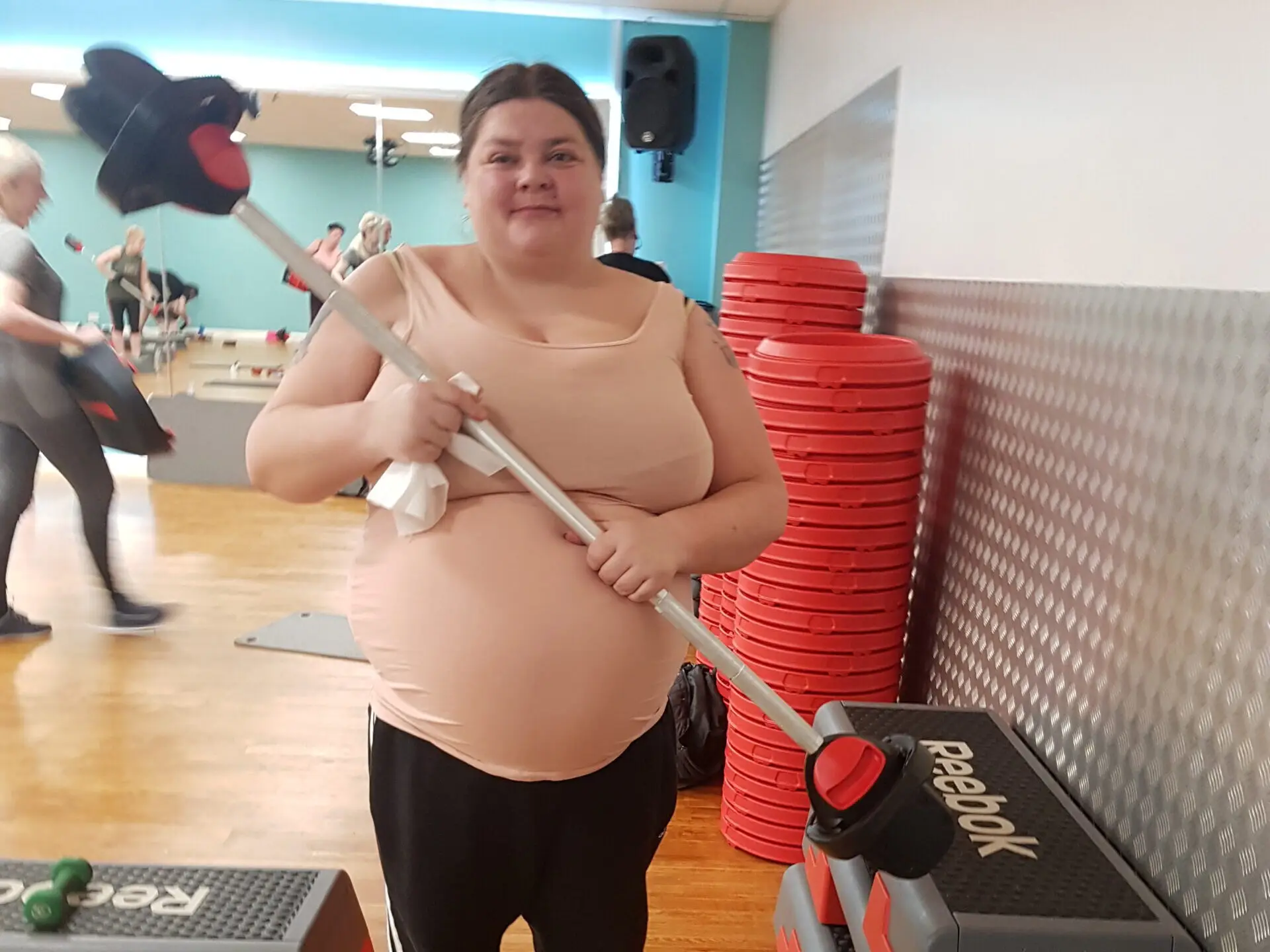 female resident holding barbell in gym