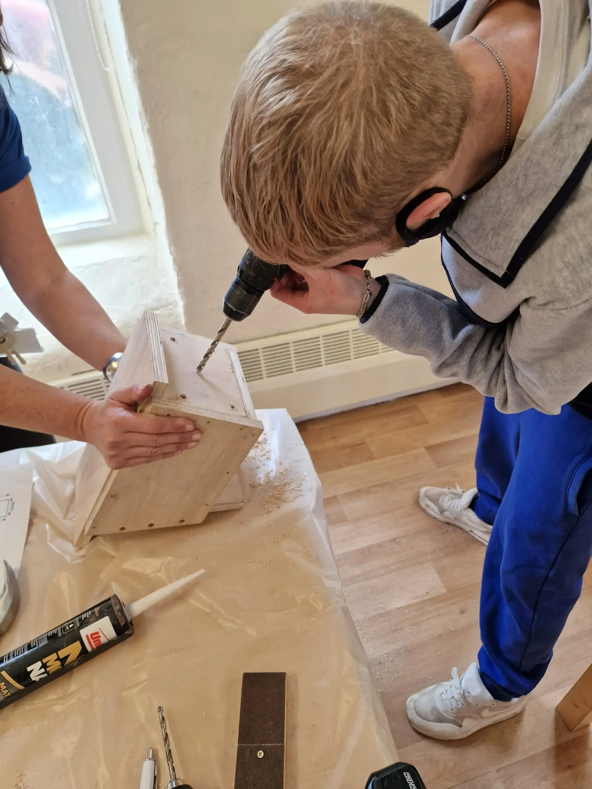drilling a hole into wooden bird box