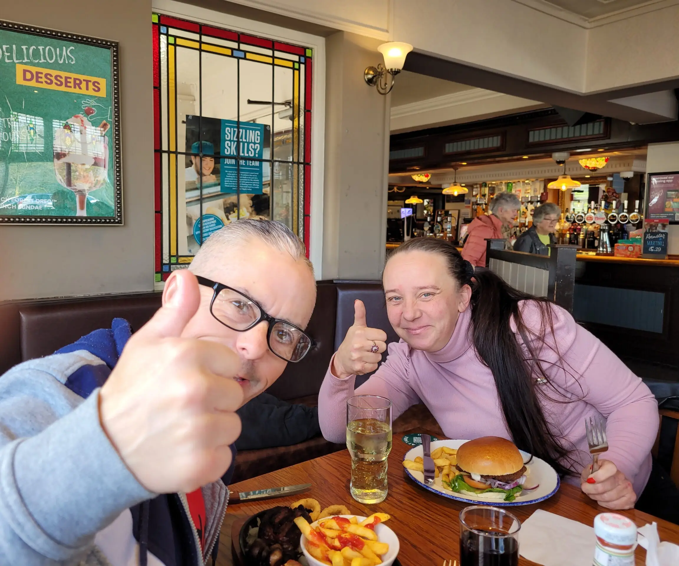 male and female putting thumbs up to camera
