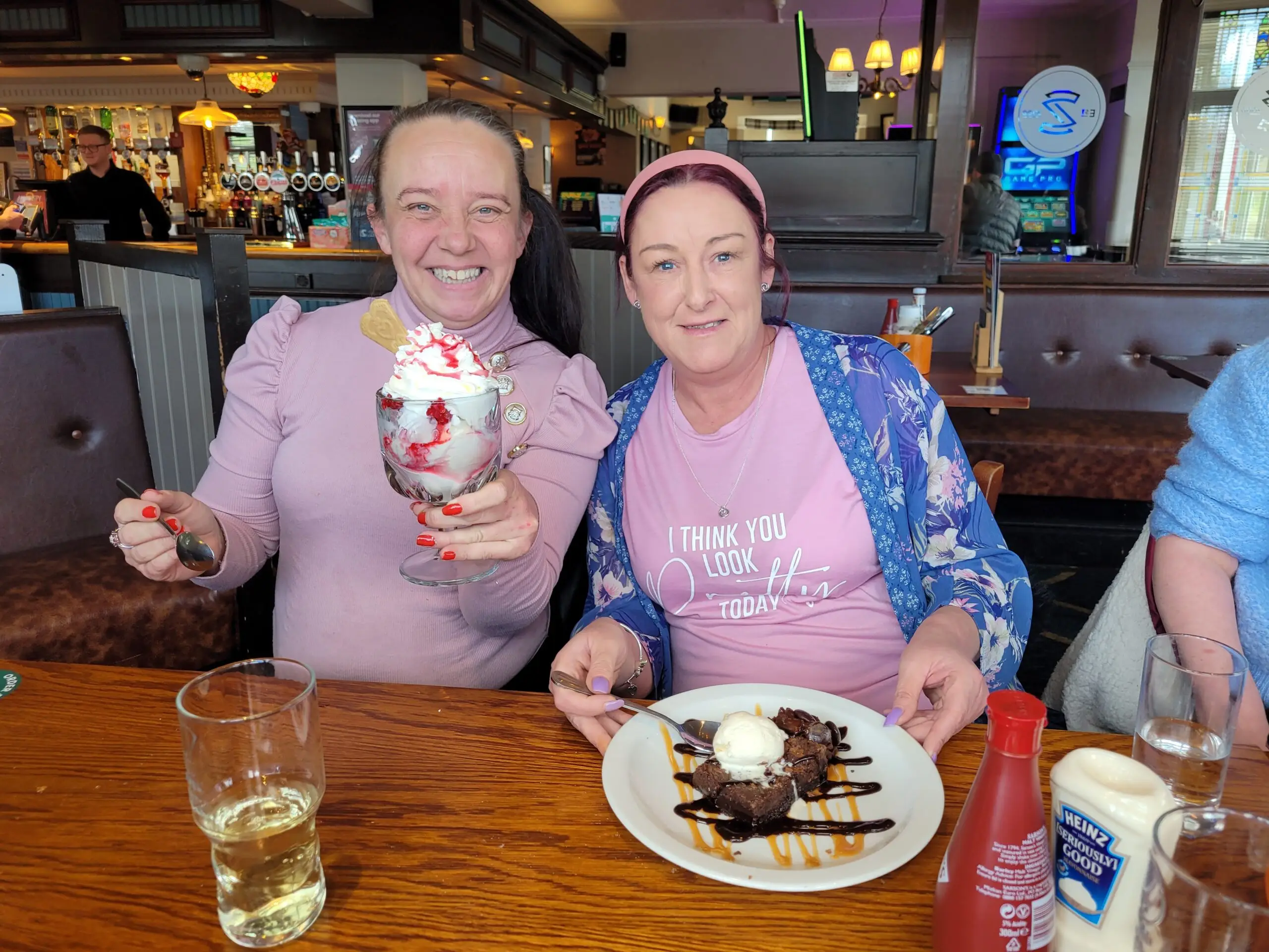 two females posing with ice cream sundae and waffles